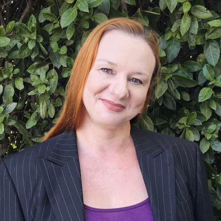 A woman with red hair and a purple shirt