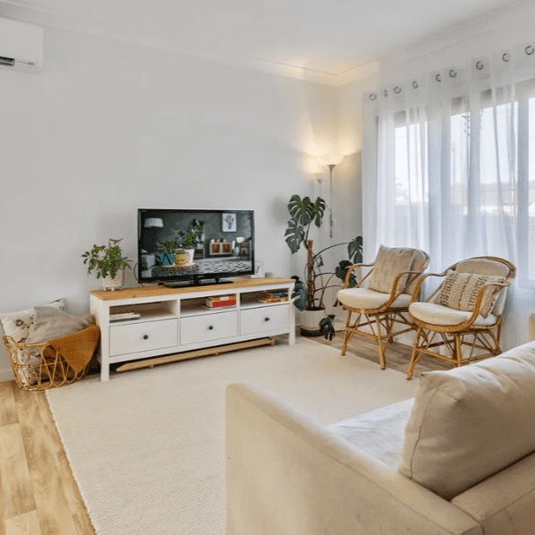 Image20250416083550 A living room with white furniture and a flat screen tv.