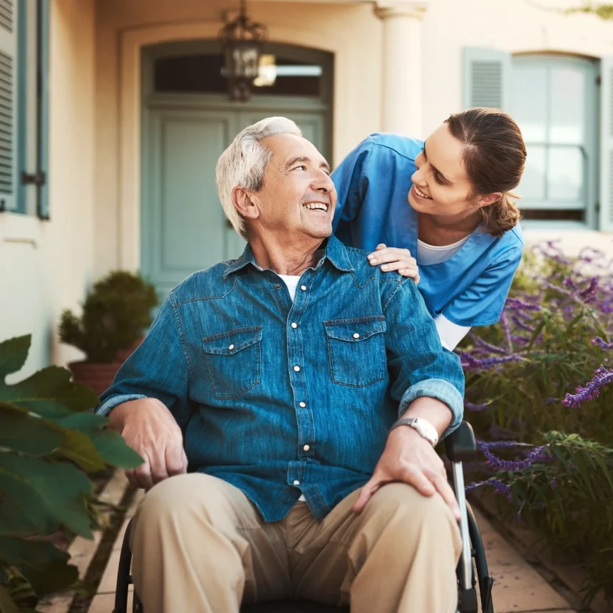 A woman is helping an older man in a wheelchair.