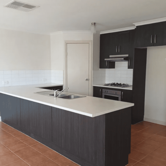 imageedit_4_3047614803 A kitchen with black cabinets and white counters.
